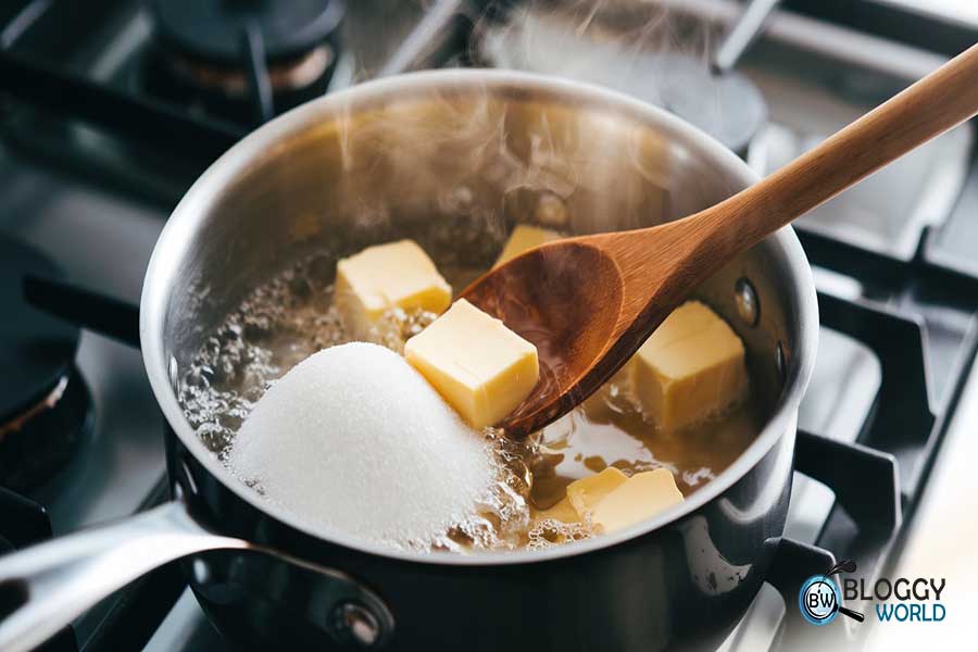 Water, butter, sugar, and salt in a medium saucepan heating on a stove. to make homemade churros